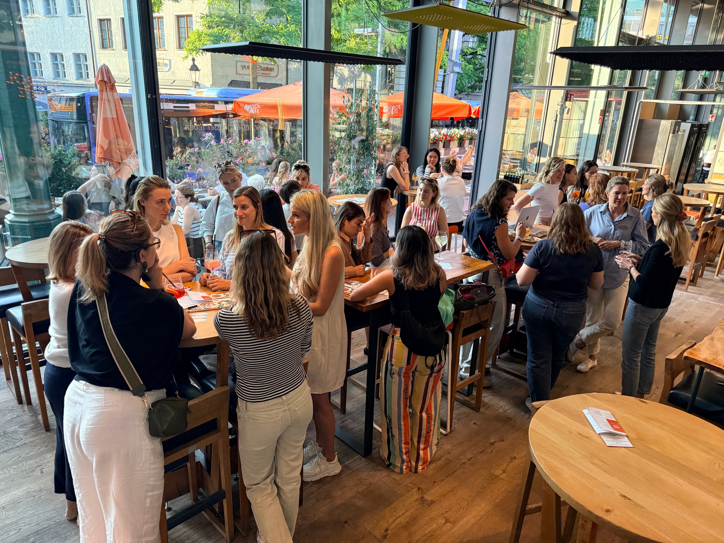 Women talking around standing tables at the first Women in AI Social in Munich.