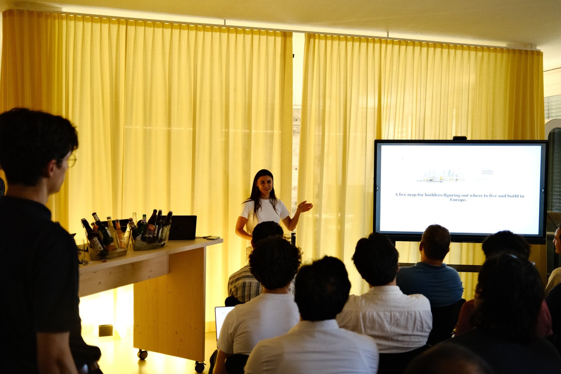 Lara presenting Just Move to Europe to a room of builders at a Munich demo night.