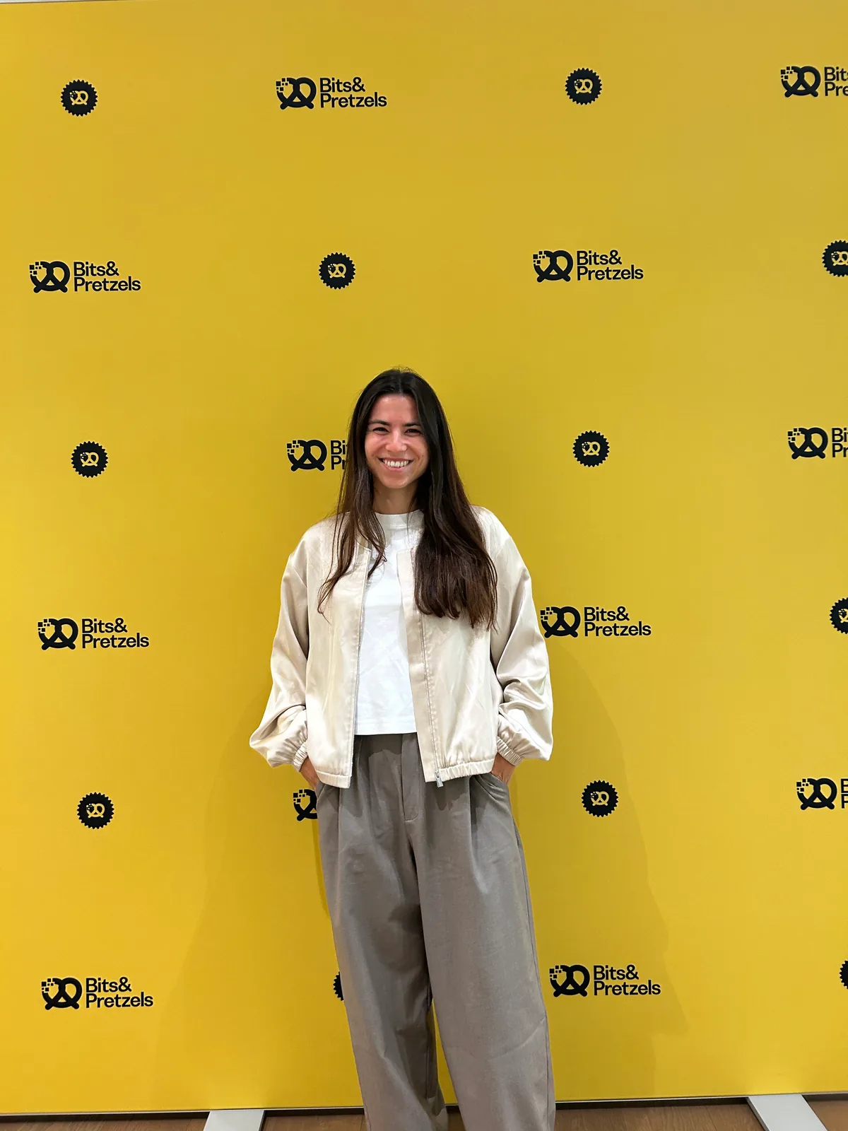 Lara smiling in front of the yellow Bits & Pretzels backdrop.