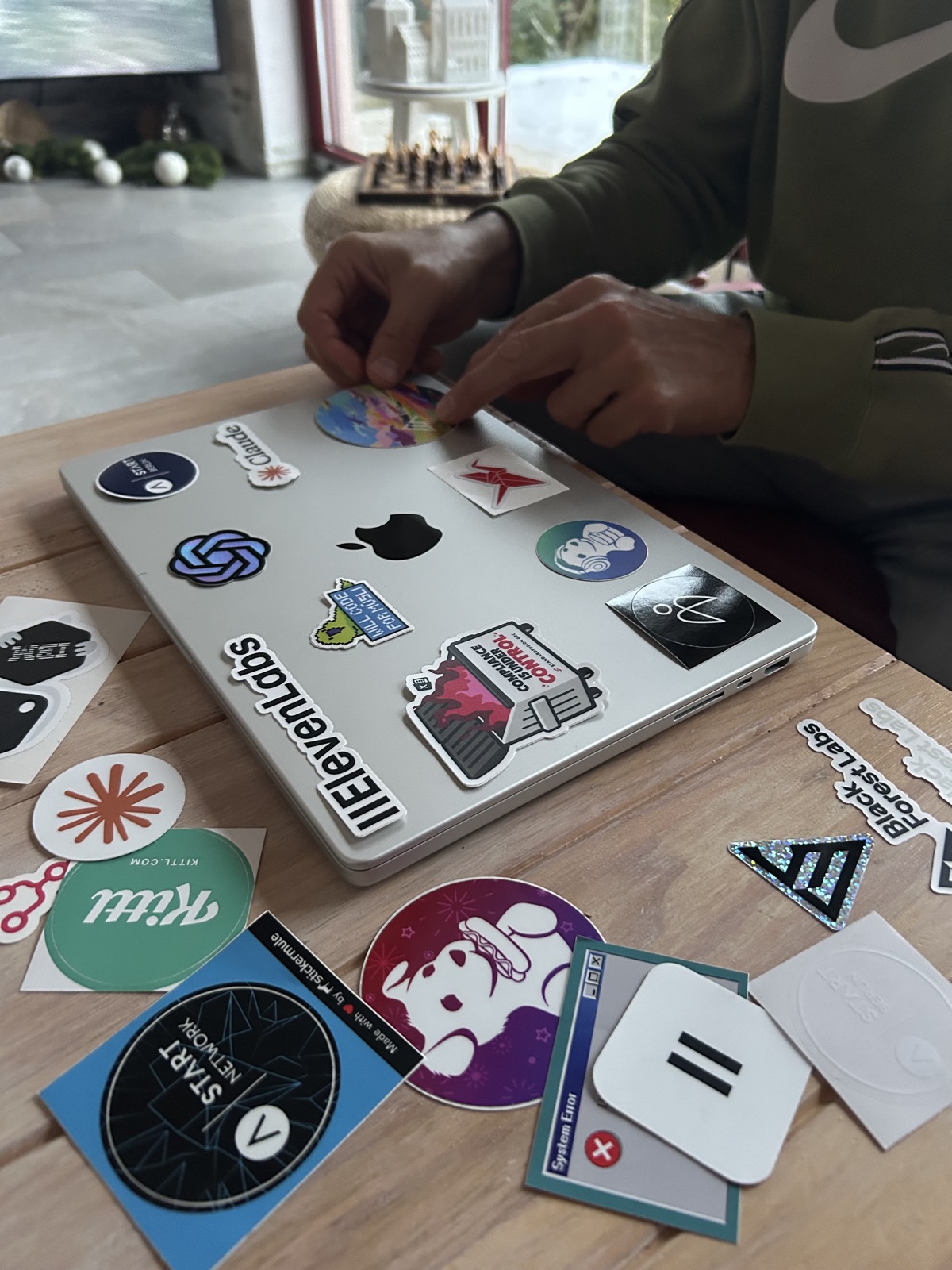 Lara's dad helping her arrange tech stickers on the closed lid of her laptop.