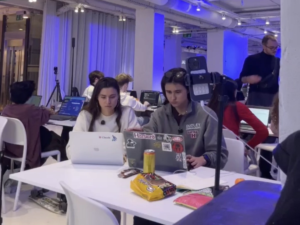 Lara working at a table during an AI course or hackathon build session.